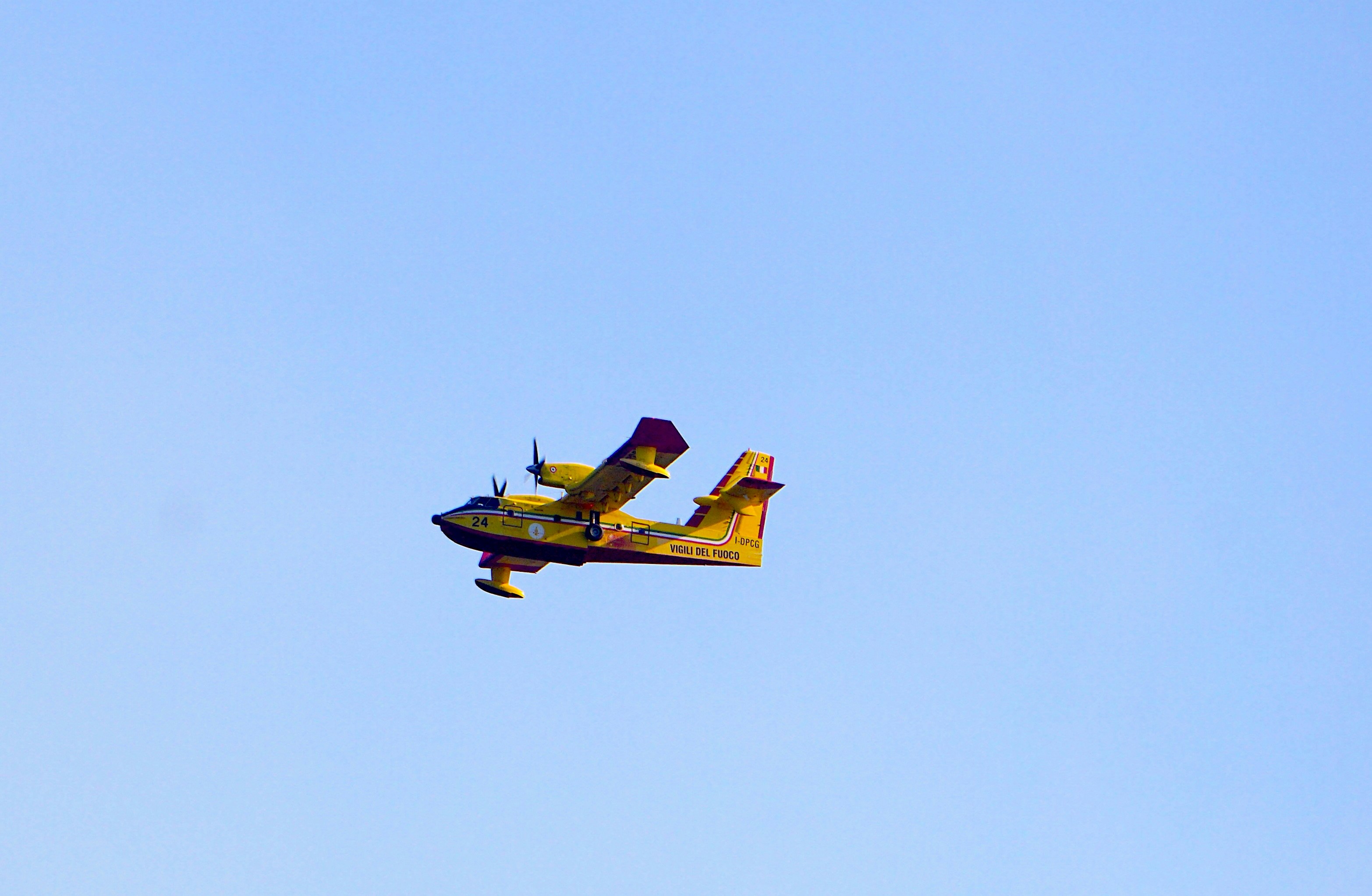A small plane flying through a blue sky