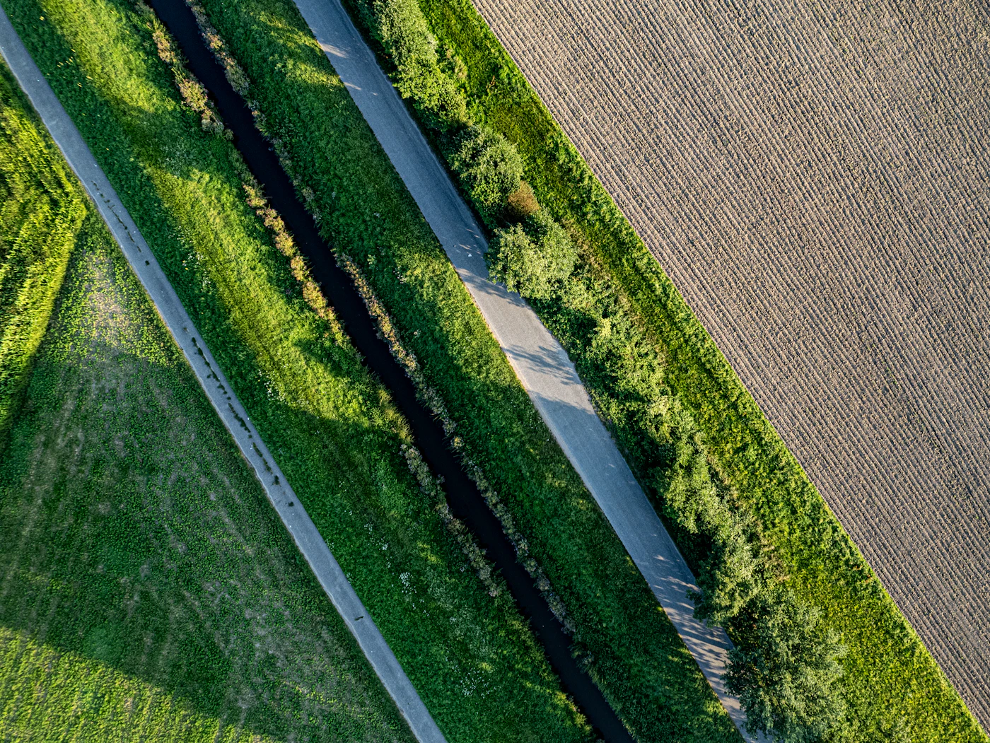 Irrigation canal crossing cultivated plots, seen from directly above