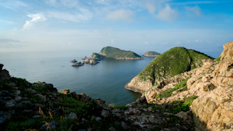 A body of water surrounded by rocks and grass