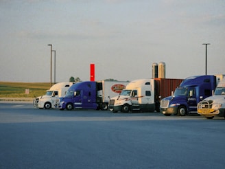 A row of semi trucks parked in a parking lot