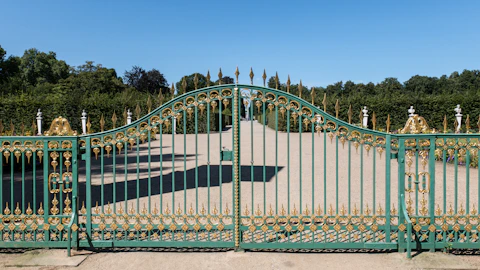 A large green gate with a walkway leading to it