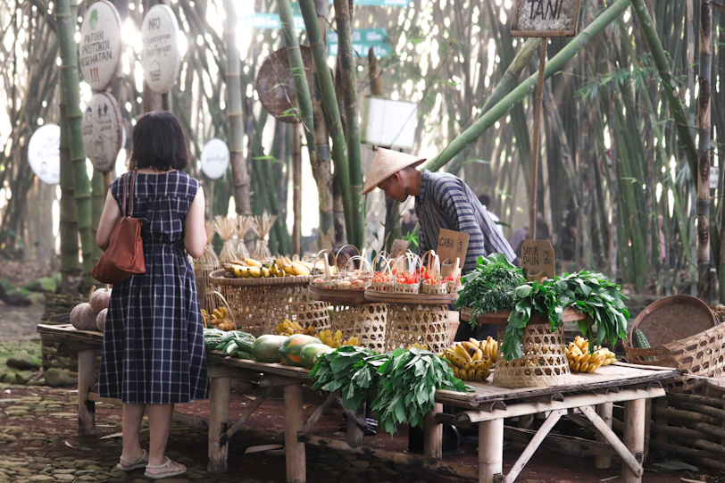 A man and a woman standing in front of a table filled with fruits and vegetables