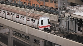 A train traveling down tracks next to a tall building