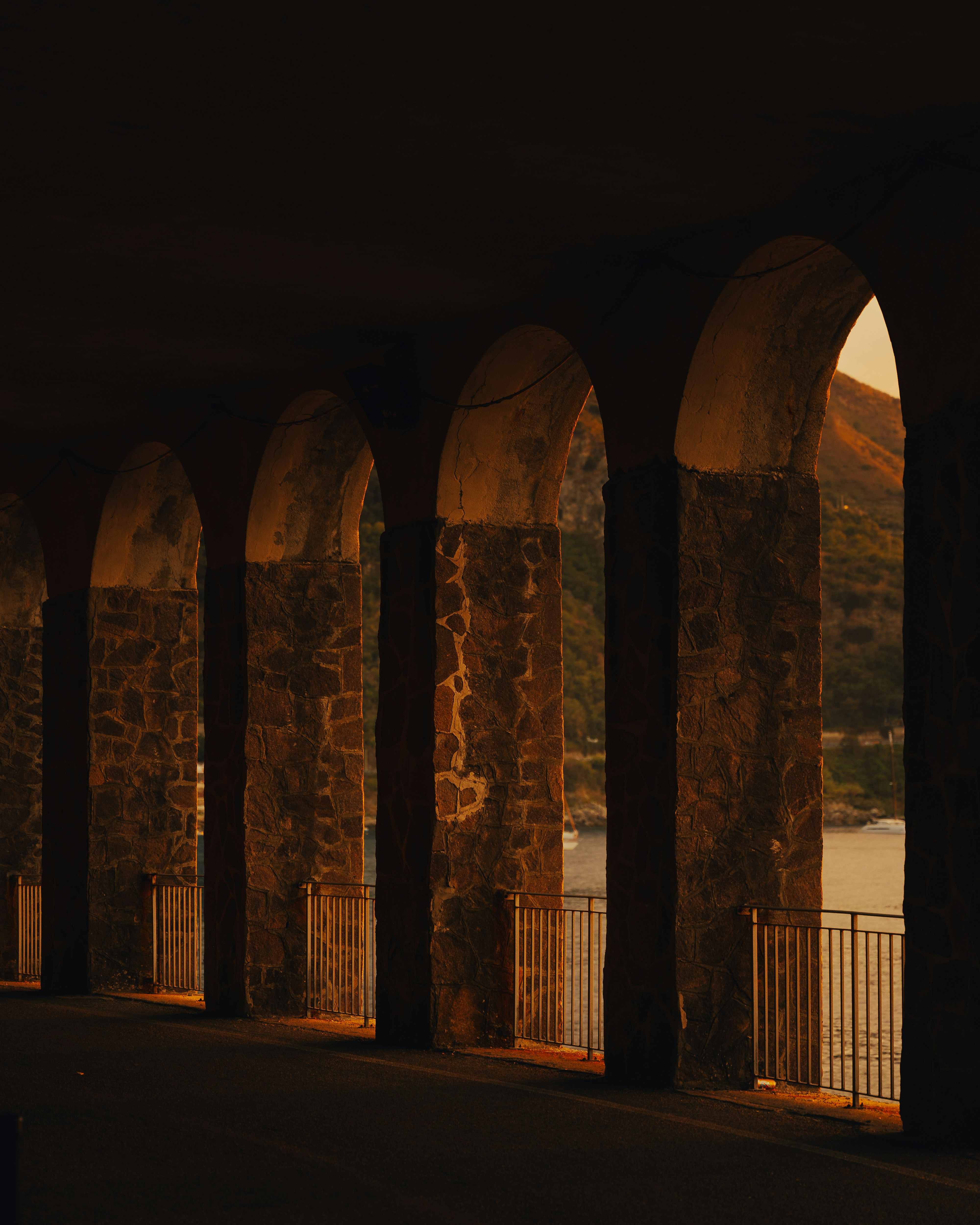 A row of arches with a body of water in the background
