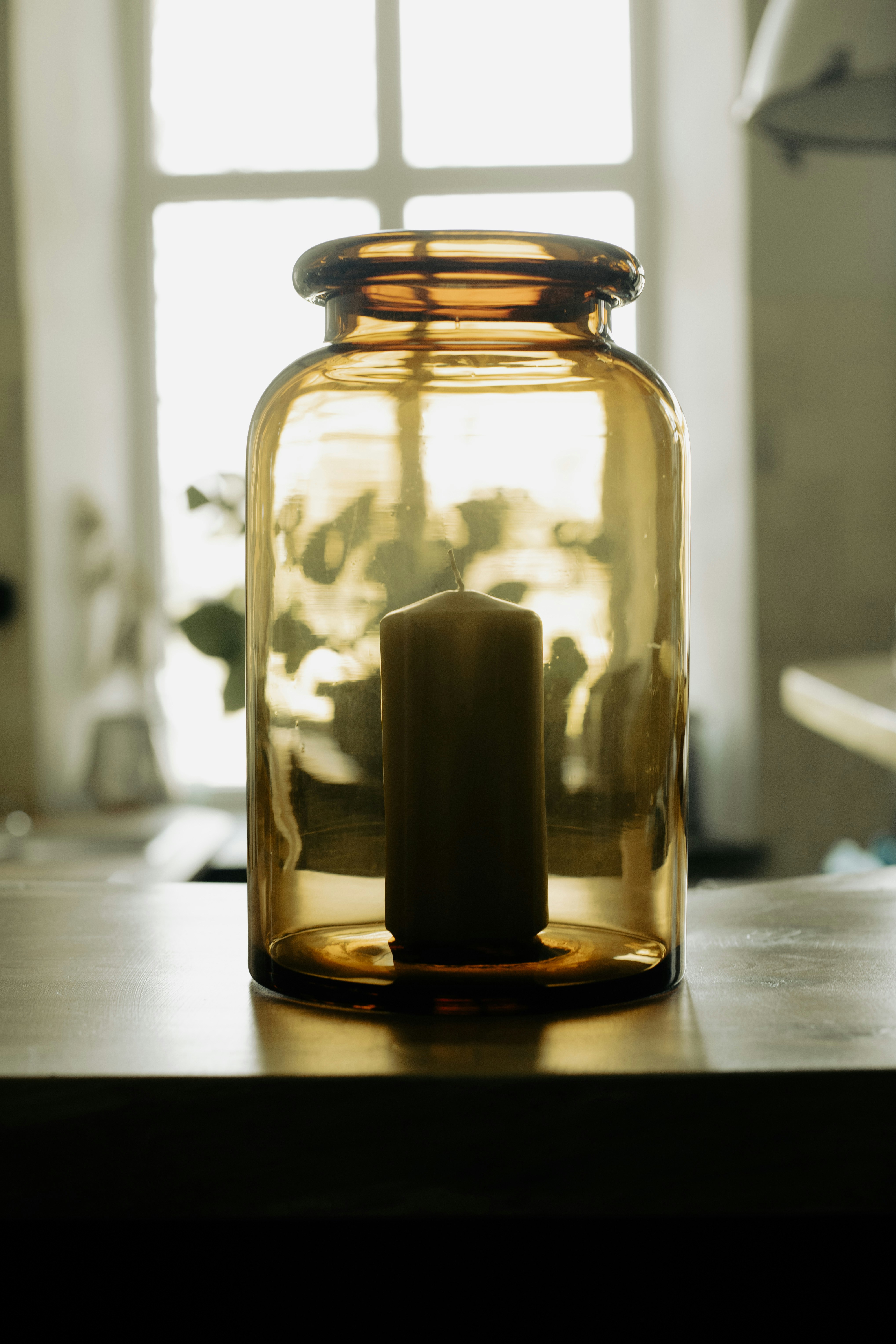 A glass jar with a candle inside of it