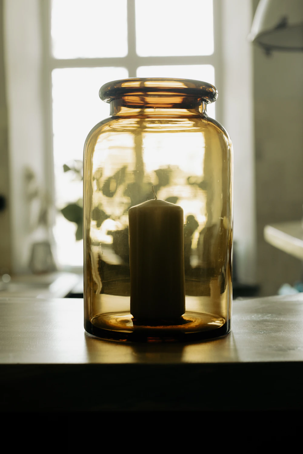 A softly lit candle in a glass jar
