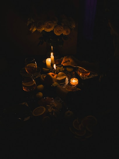 A table topped with candles and plates of food