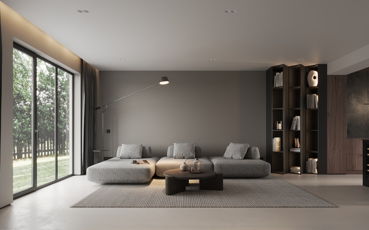 A bright modern living room with full-height glazing opening onto a garden, illustrating good daylight provision