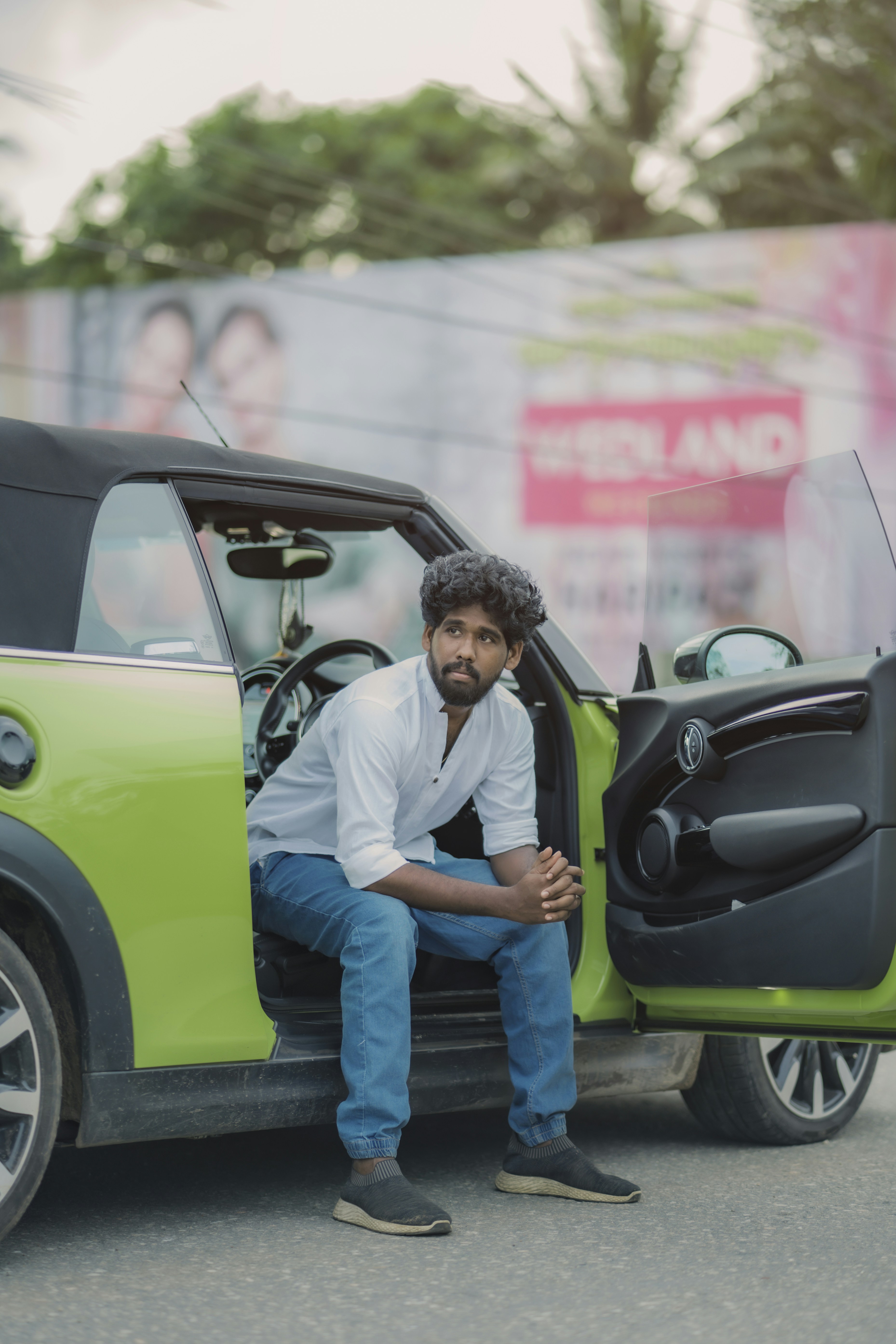 A man sitting in the back of a green car