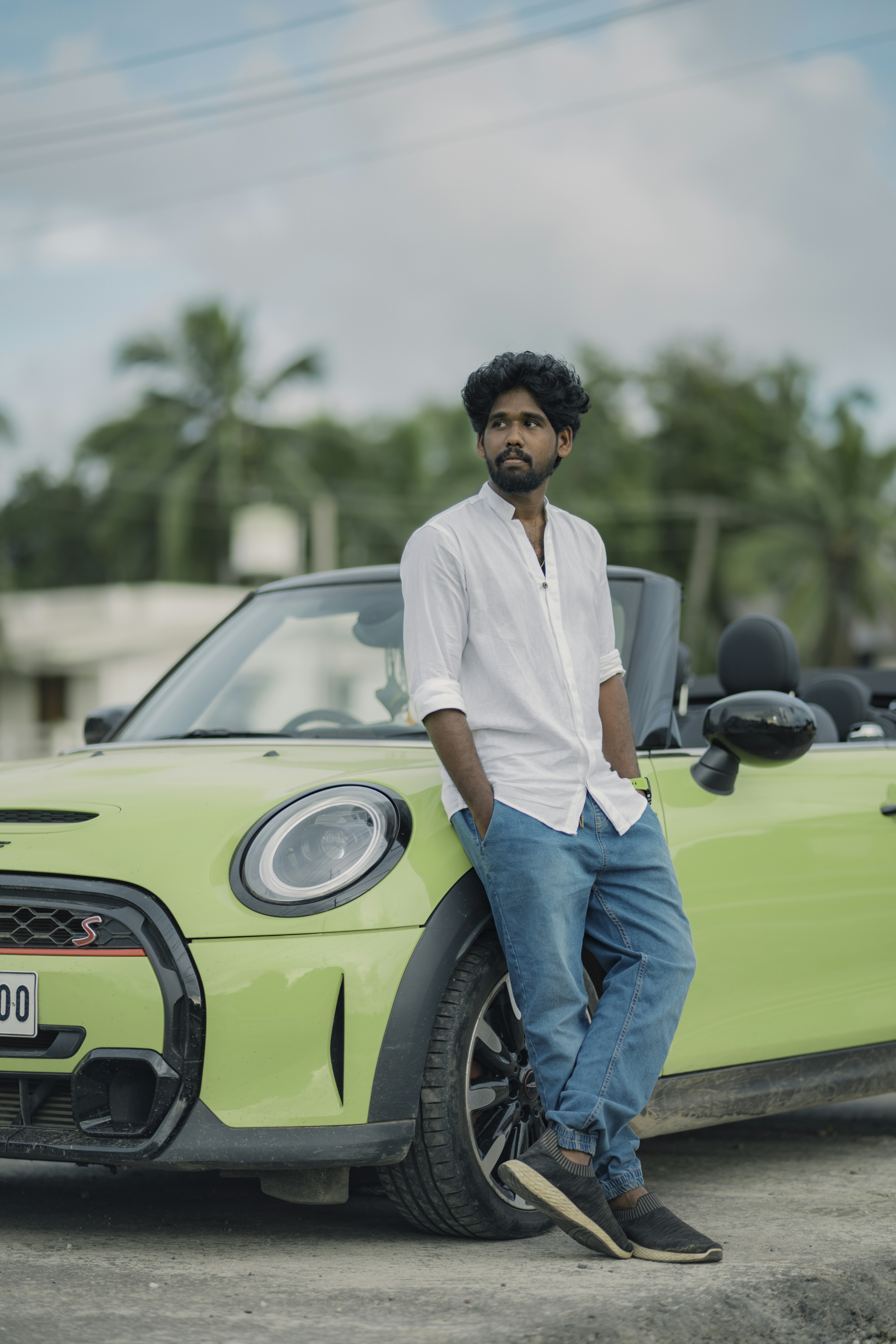 A man standing next to a green car
