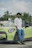 A man standing next to a green car