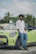 A man standing next to a green car