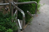 A close up of a metal hand rail on a sidewalk