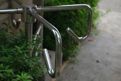 A close up of a metal hand rail on a sidewalk