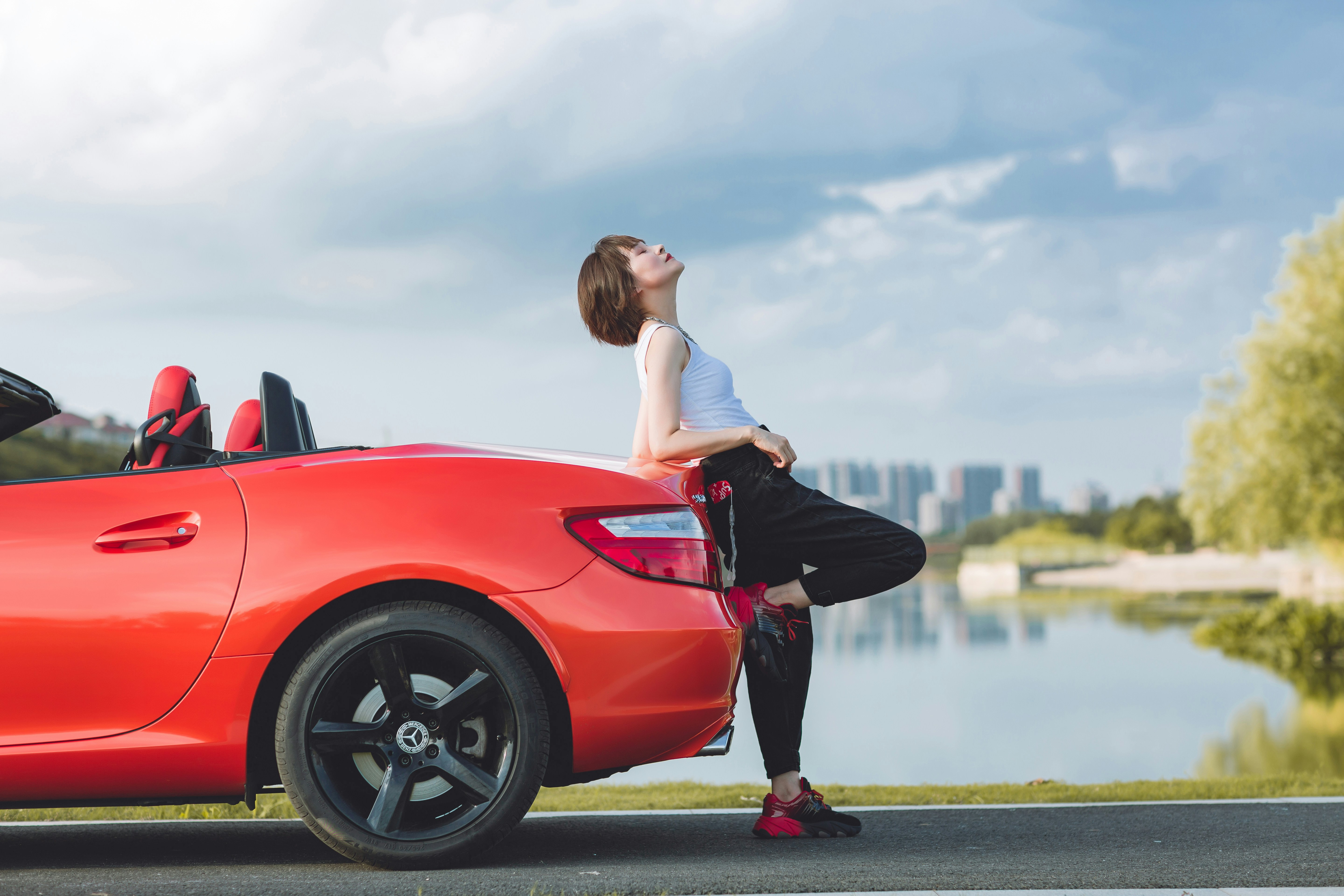 A woman sitting on the hood of a red sports car photo – Free Image on ...