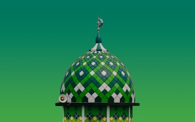 A green and white building with a clock on top