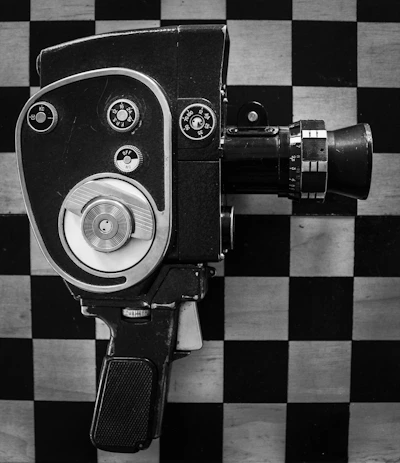 A black and white photo of a camera on a checkered wall