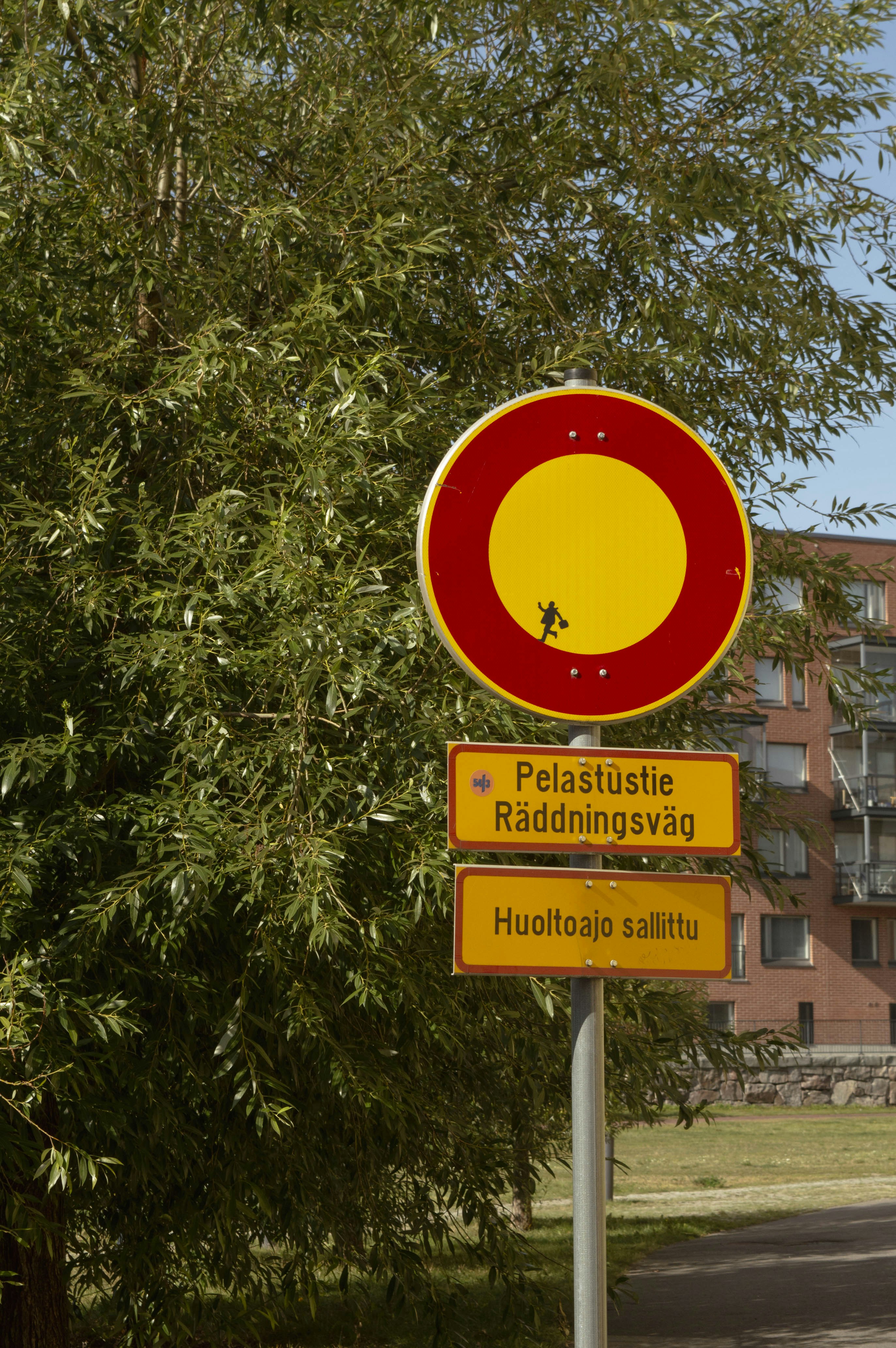 A red and yellow sign sitting on the side of a road