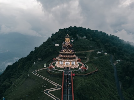 An aerial view of a mountain with a statue on top of it