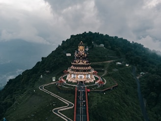 An aerial view of a mountain with a statue on top of it