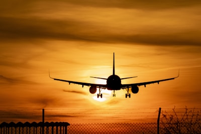 A plane is flying in the sky at sunset