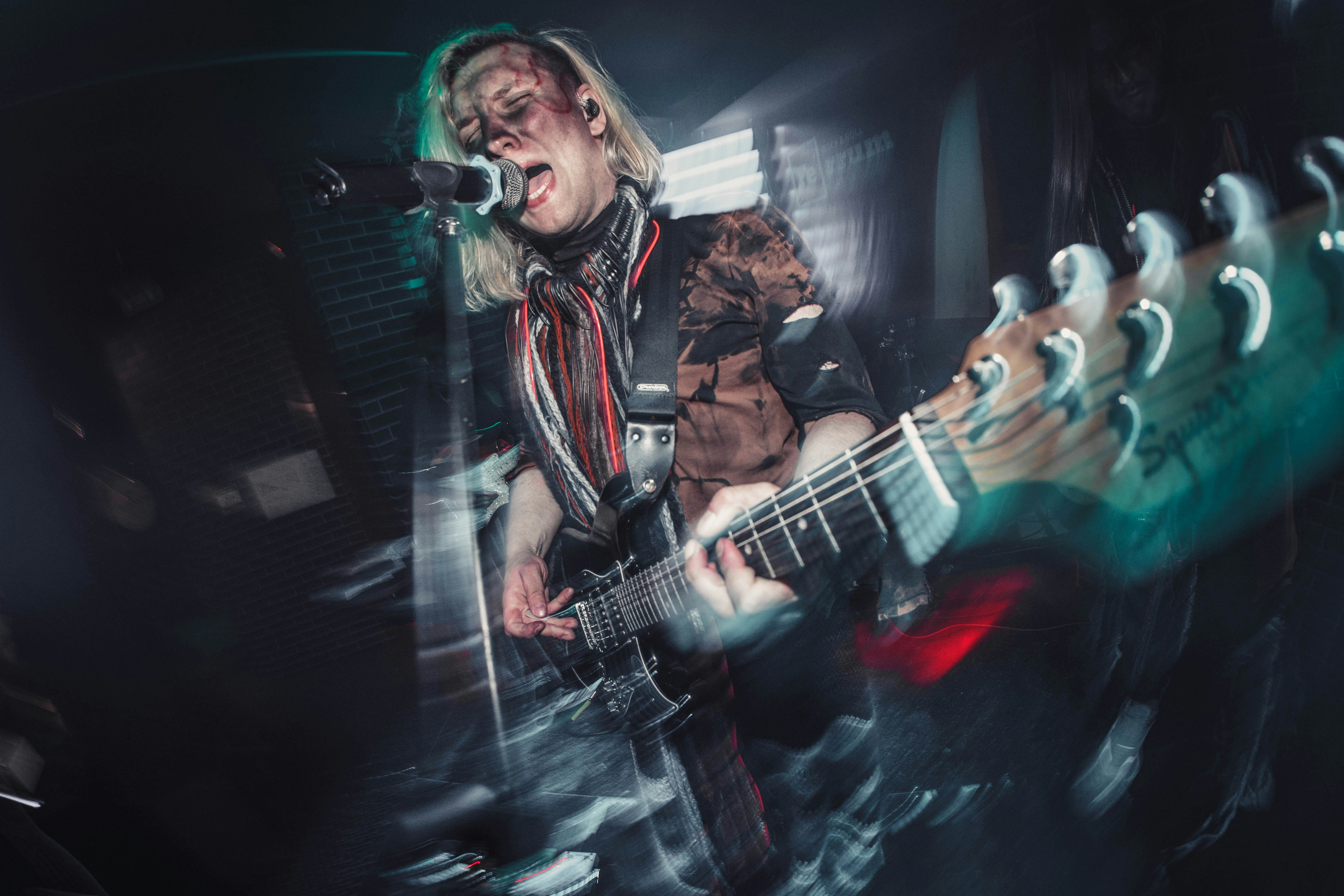 A man playing a guitar in front of a microphone