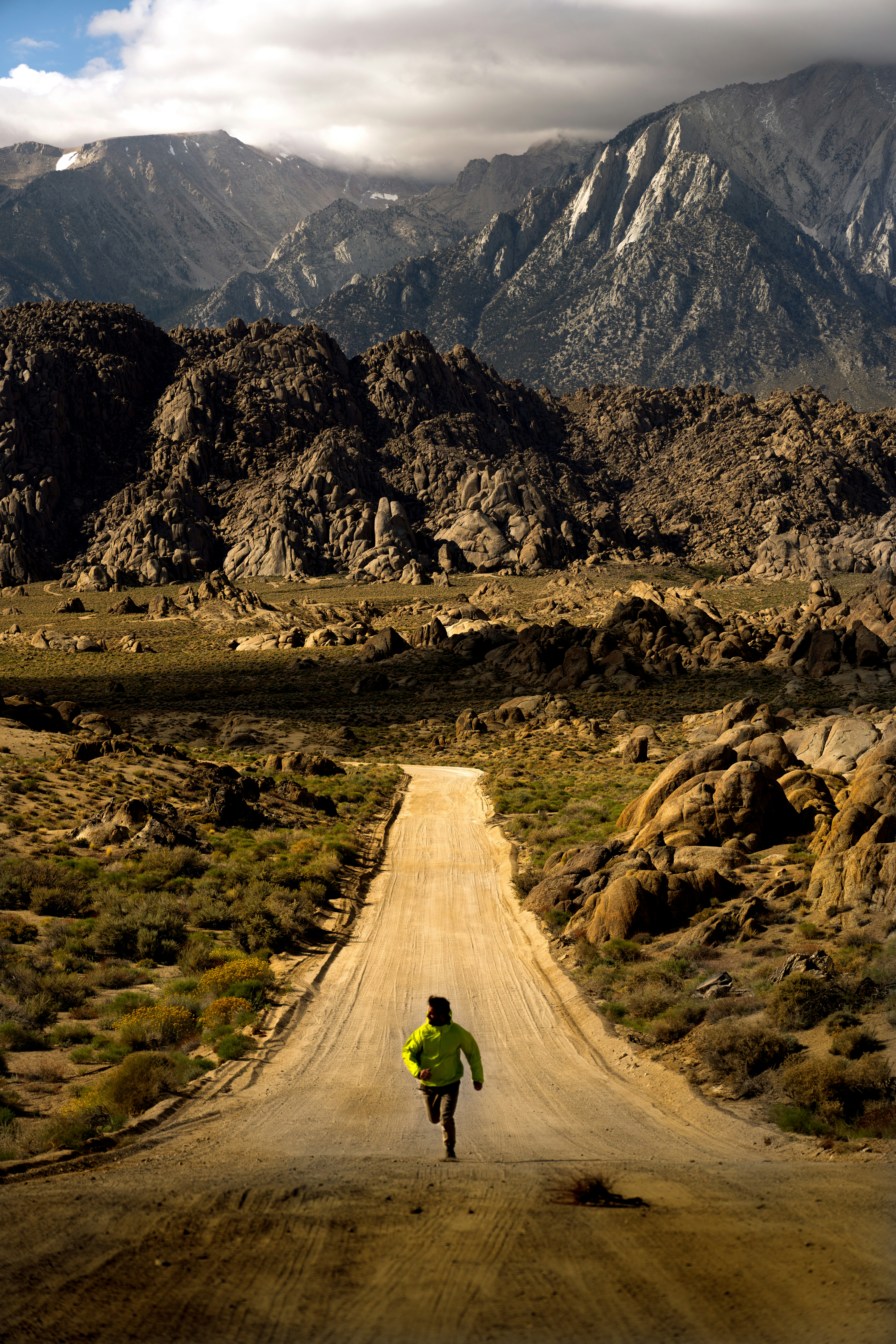 A person running down a dirt road in the mountains
