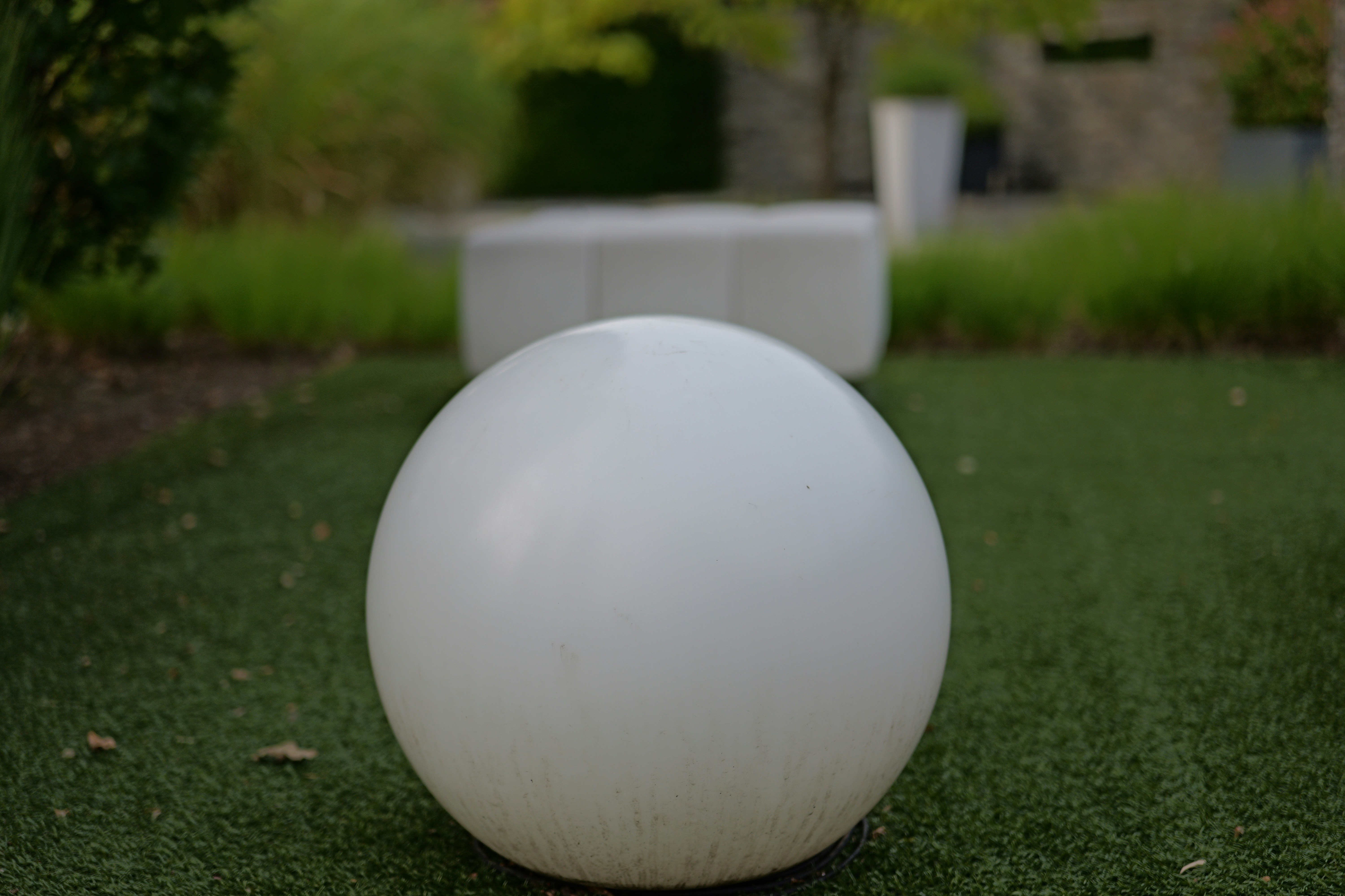 A large white ball sitting on top of a lush green field