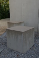 Two concrete boxes sitting on top of a gravel field