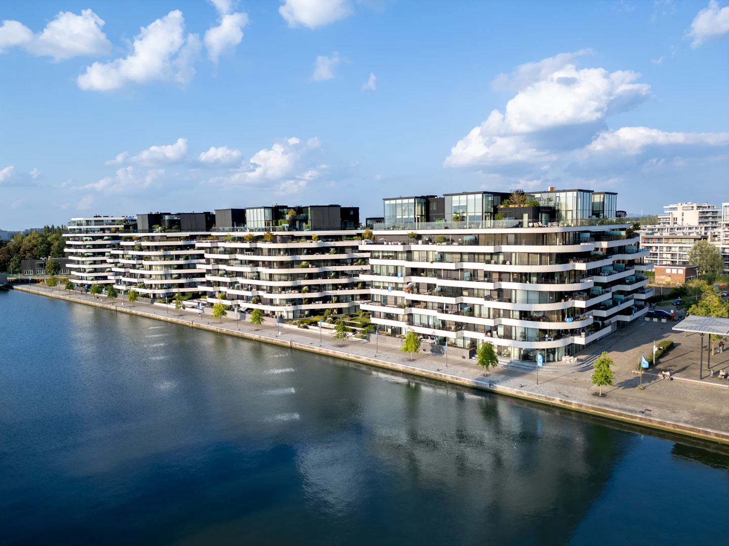 Modern apartment buildings along a calm waterfront
