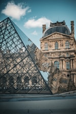 A large building with a glass pyramid in front of it