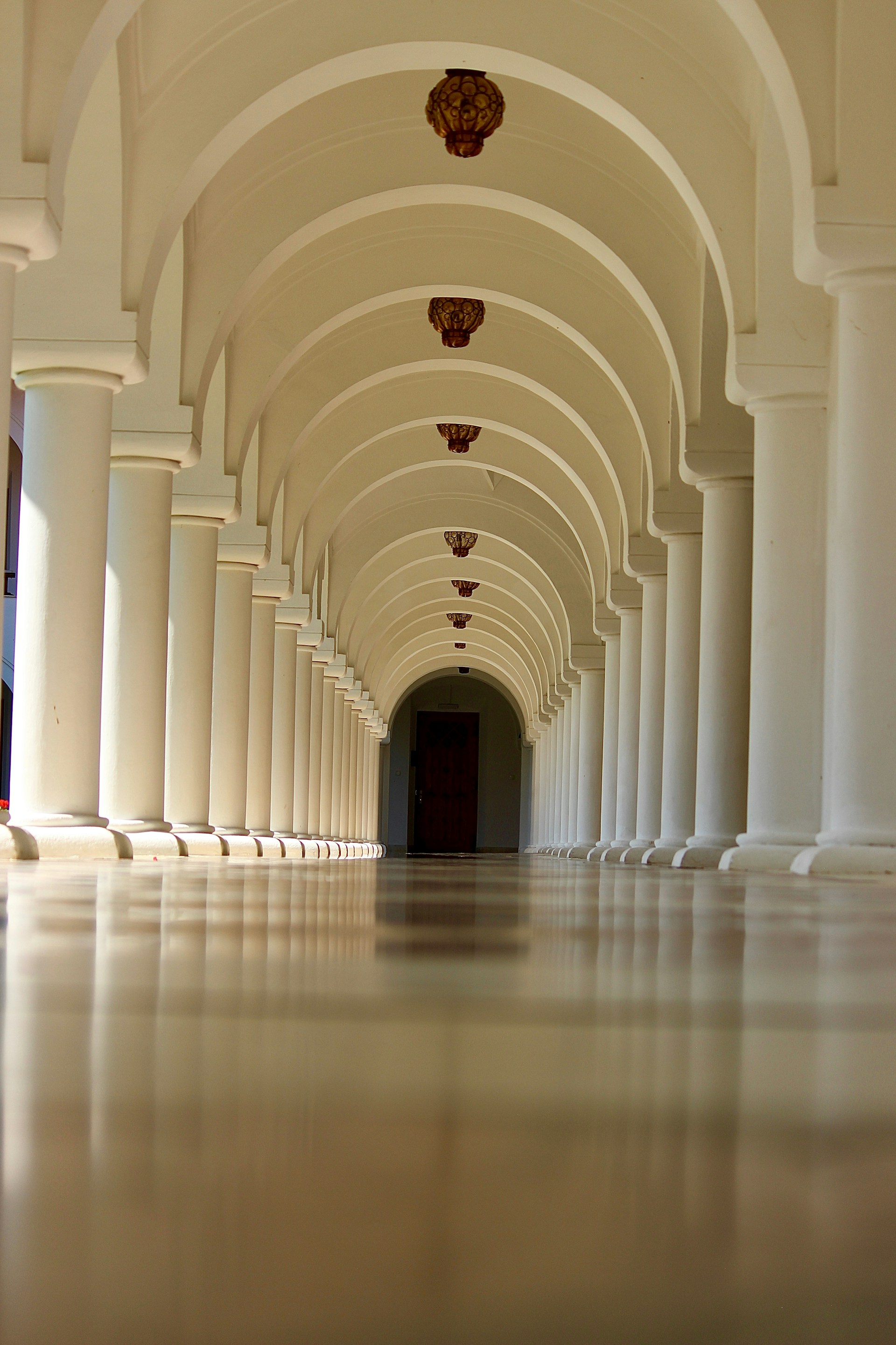 A long hallway with columns and a clock on the wall