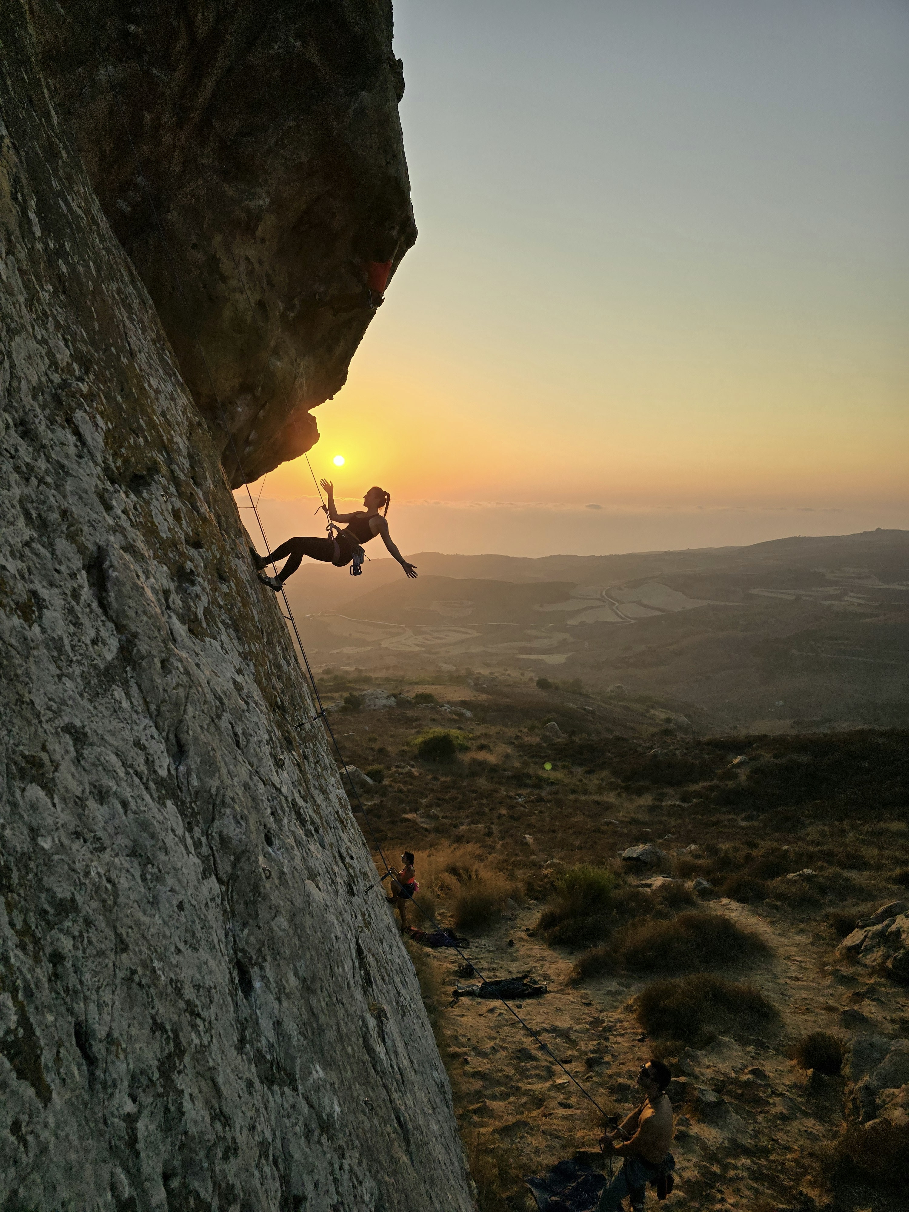 Un uomo che si arrampica sul fianco di una montagna