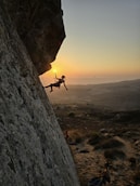 A man climbing up the side of a mountain