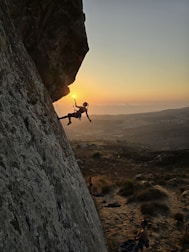 A man climbing up the side of a mountain