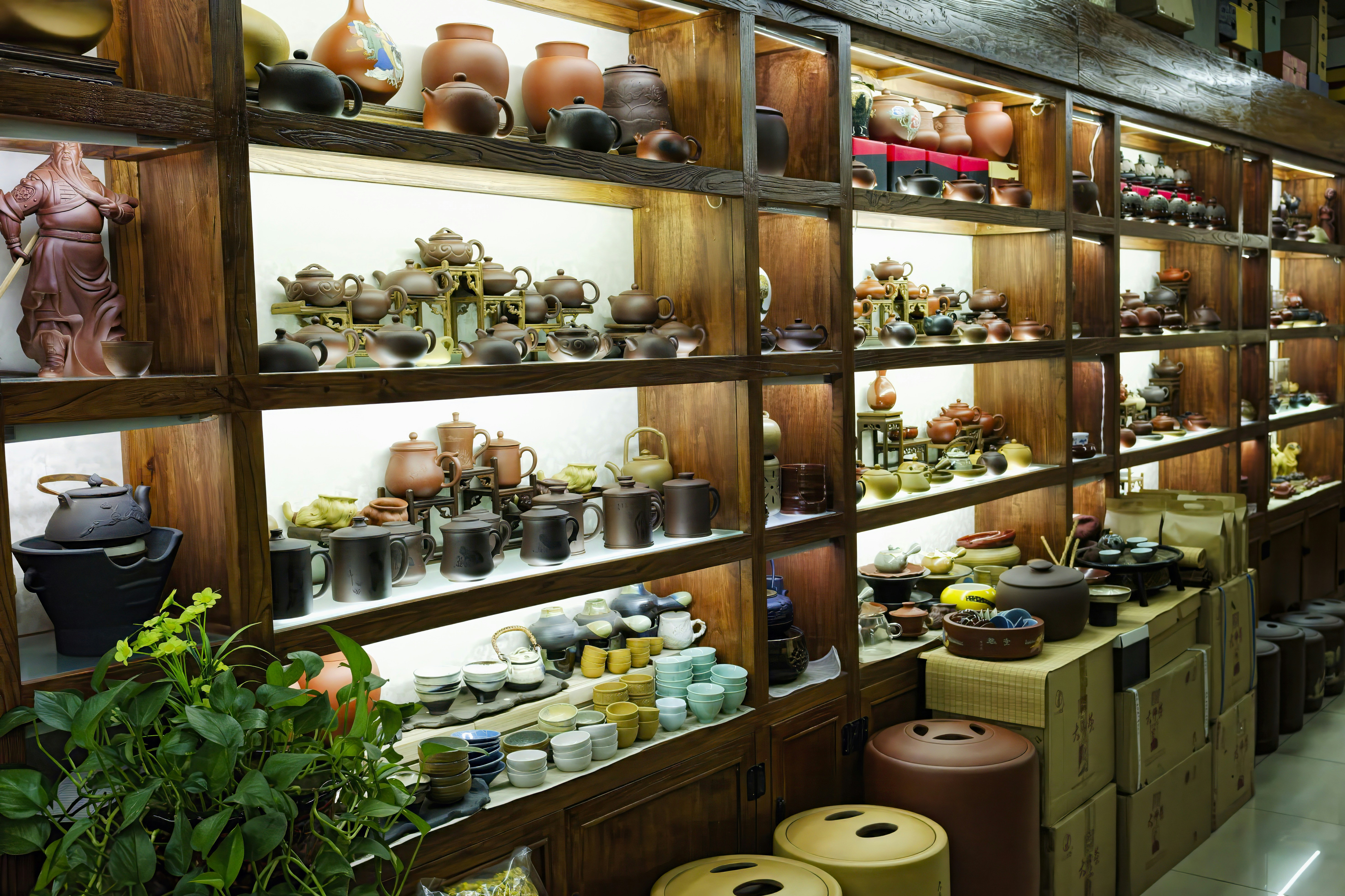 Traditional teapots on wooden shelves in tea shop