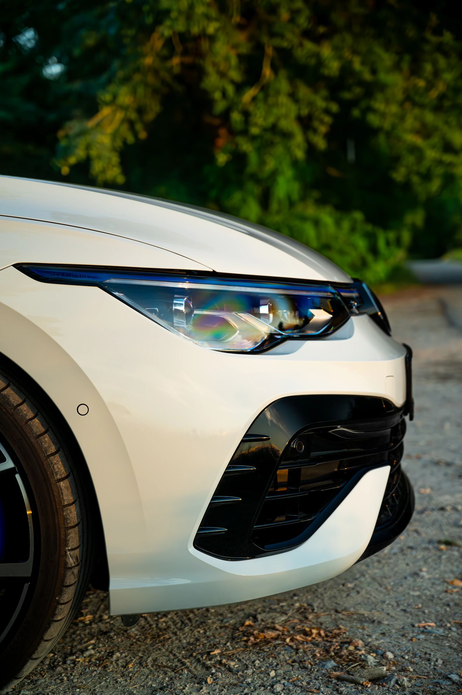 A white car parked on a gravel road