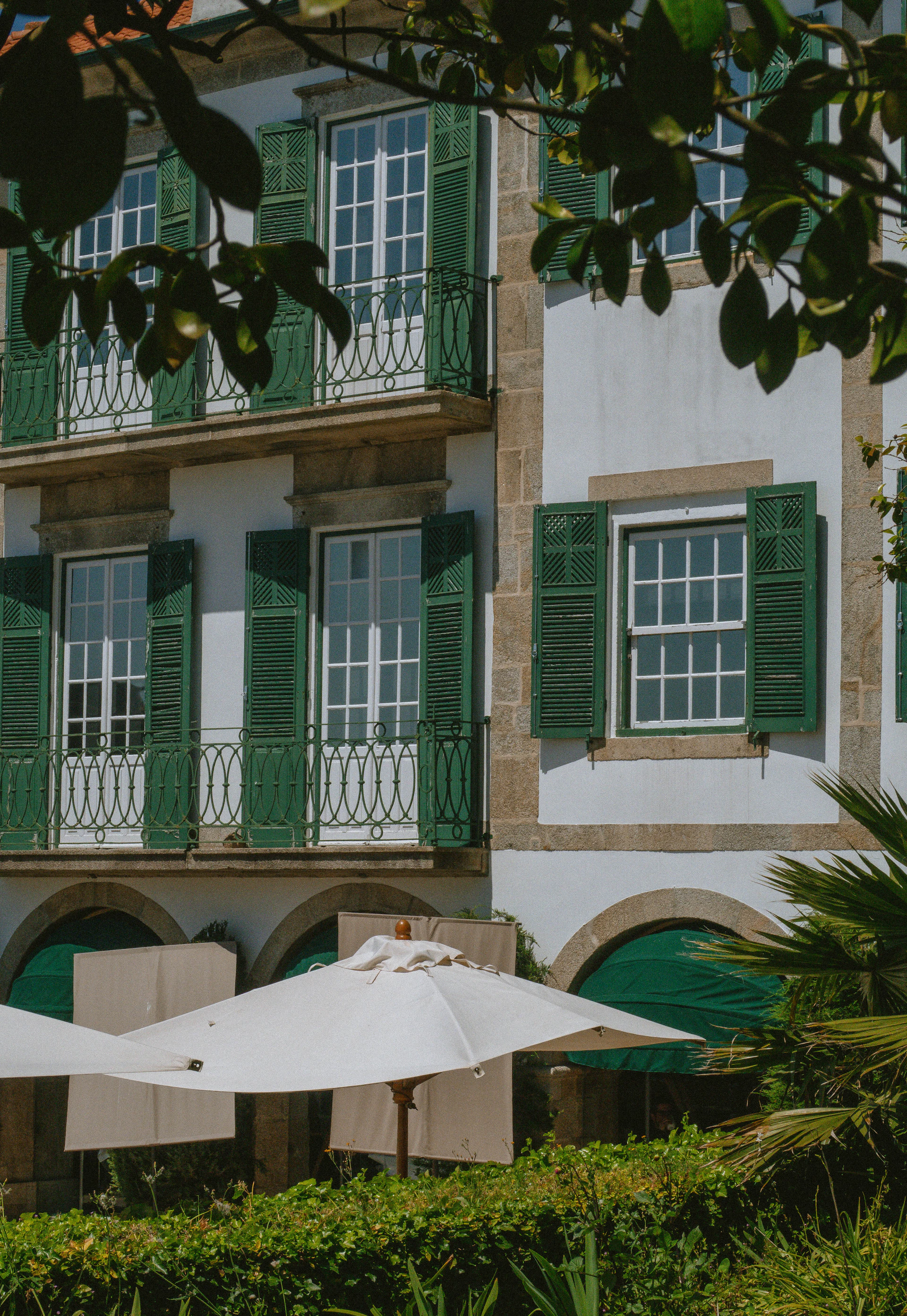A building with green shutters and white umbrellas