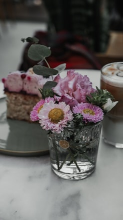 A plate with a piece of cake and flowers on it