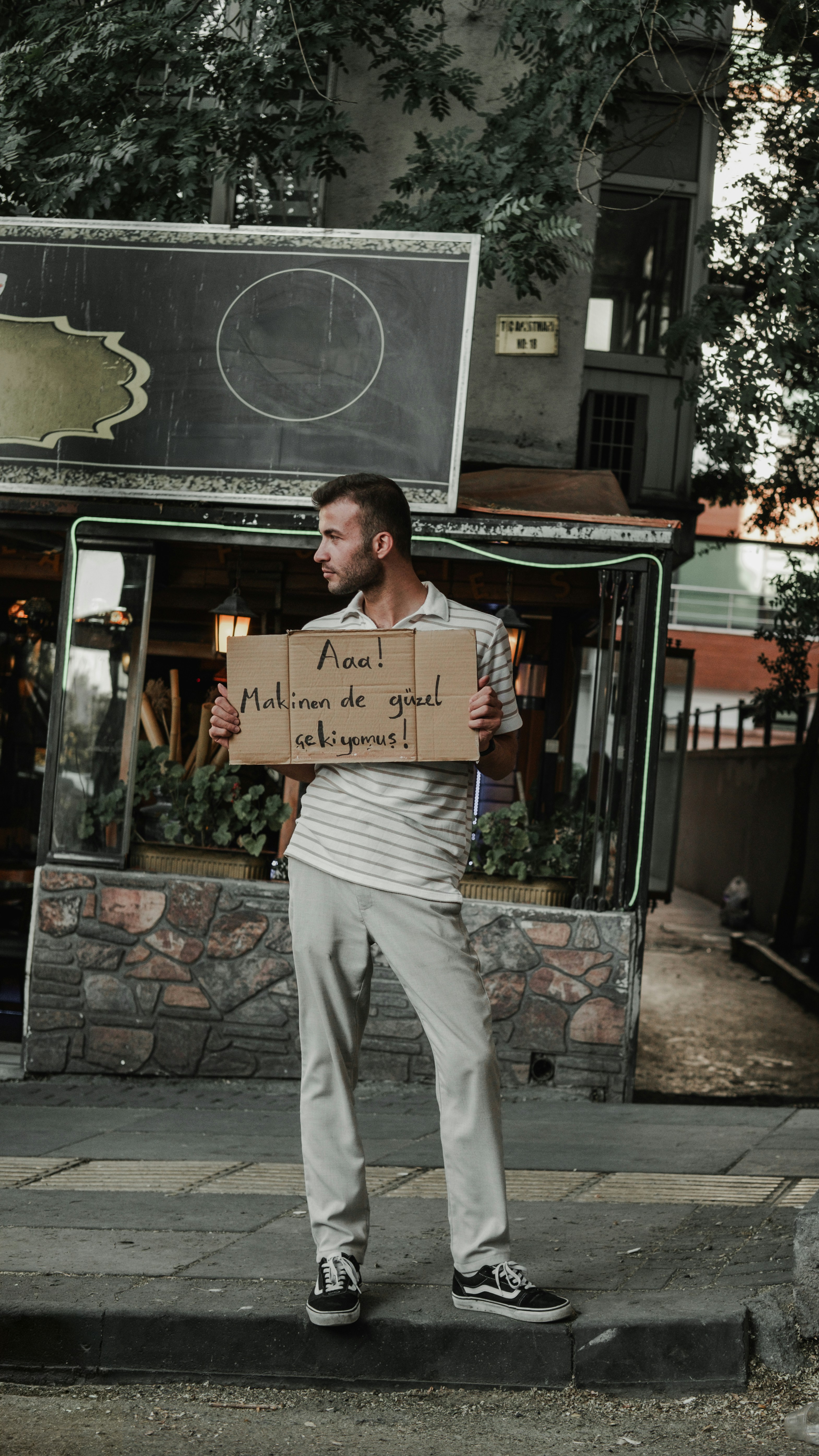A man standing on a sidewalk holding a sign