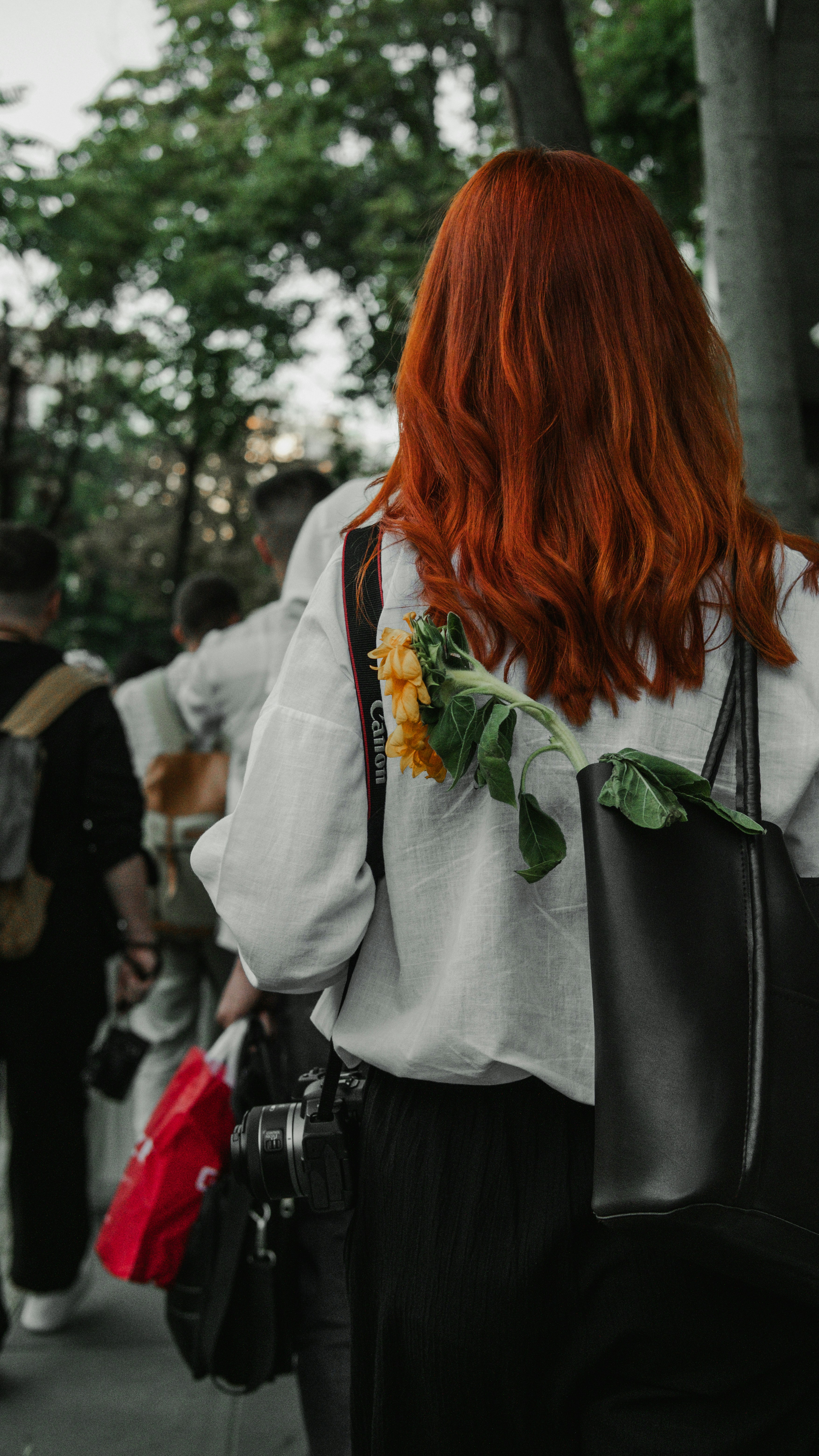 A woman with red hair is walking down the street