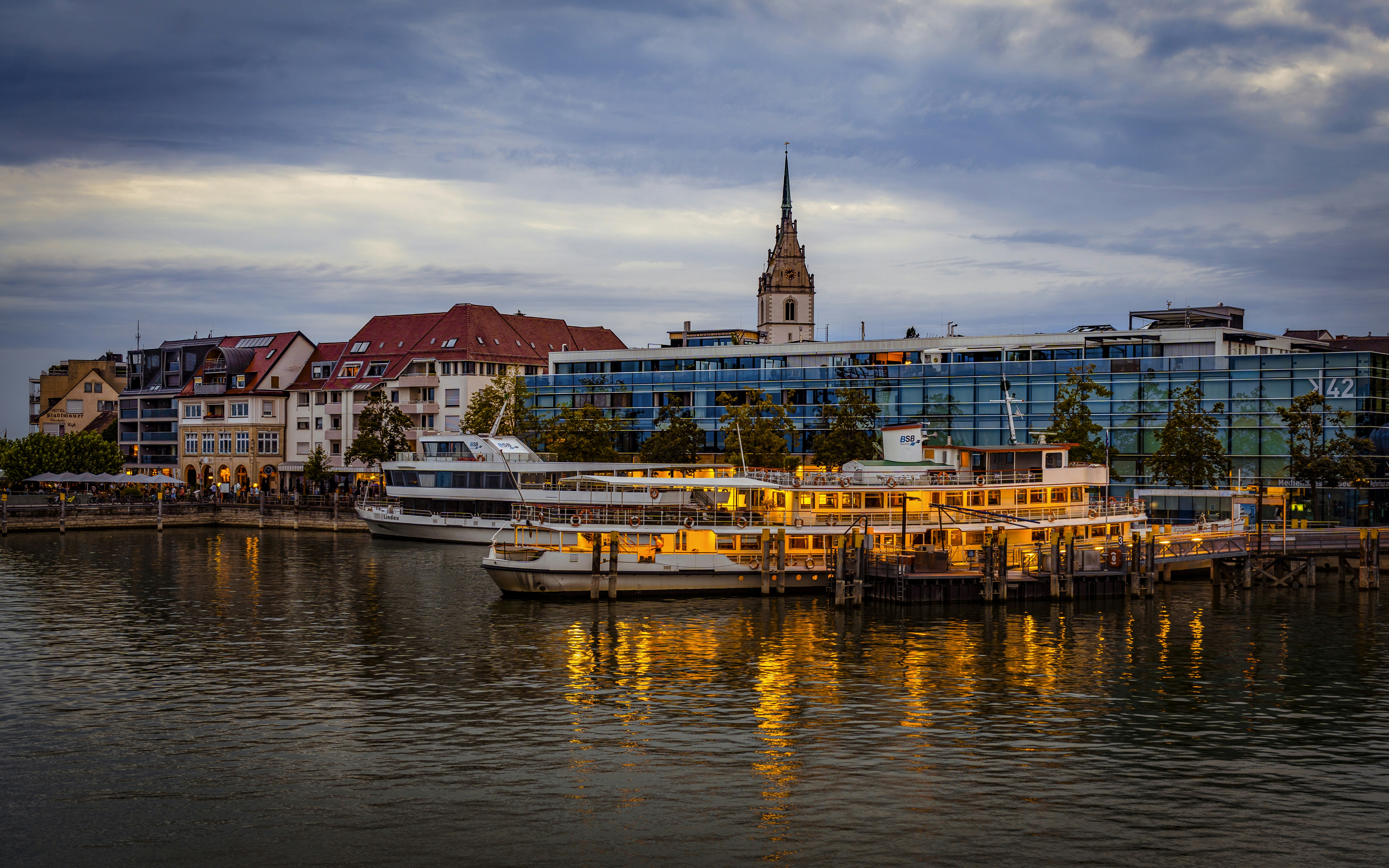 A large body of water with a bunch of boats in it, Friedrichshafen is located on the shores of Lake Constance, one of the largest lakes in Europe. The lakeside promenade in Friedrichshafen is a popular spot for locals and tourists alike. It is part of the state of Baden-Württemberg and is known for its beautiful lakeside setting, rich history, and significance in aviation and technology.