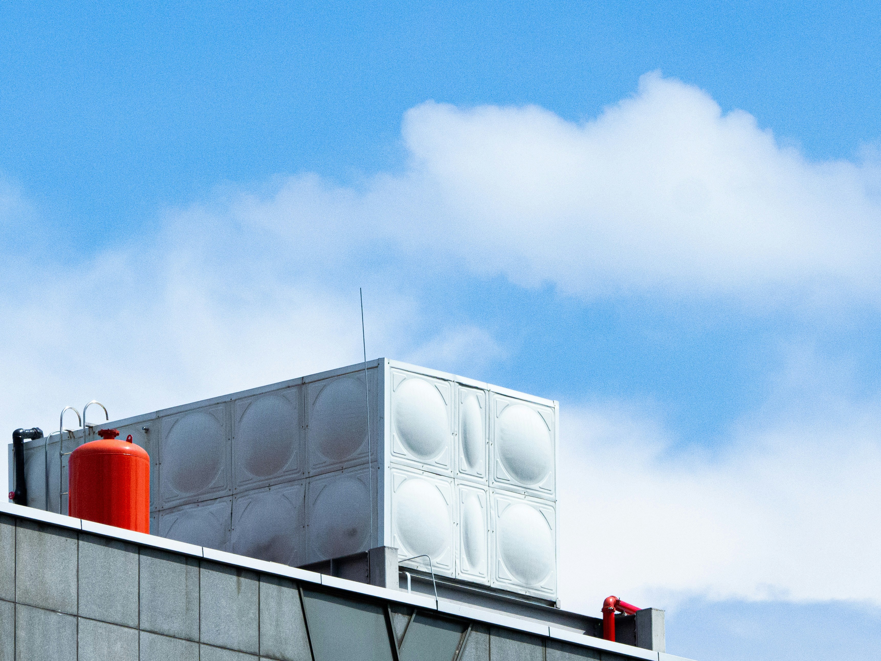 A tall building with a red and white object on top of it