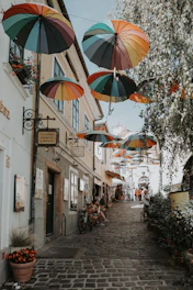 Several umbrellas hanging from the side of a building
