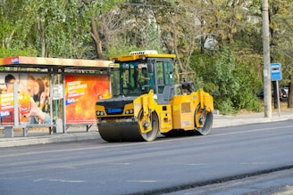 A yellow bulldozer is parked on the side of the road