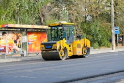 A yellow bulldozer is parked on the side of the road
