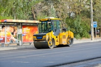 A yellow bulldozer is parked on the side of the road