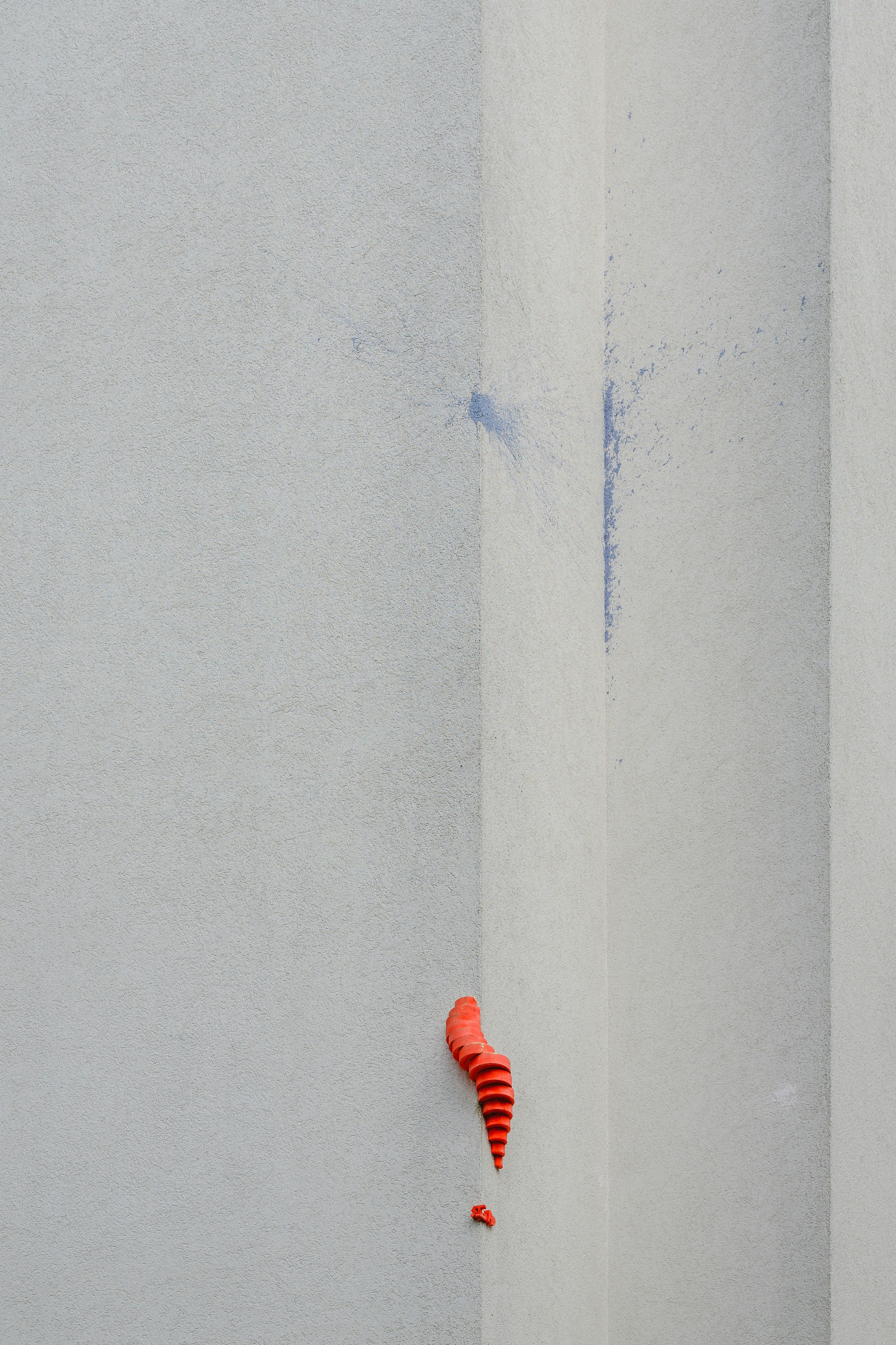 A red object sticking out of the side of a white wall photo – Free ...