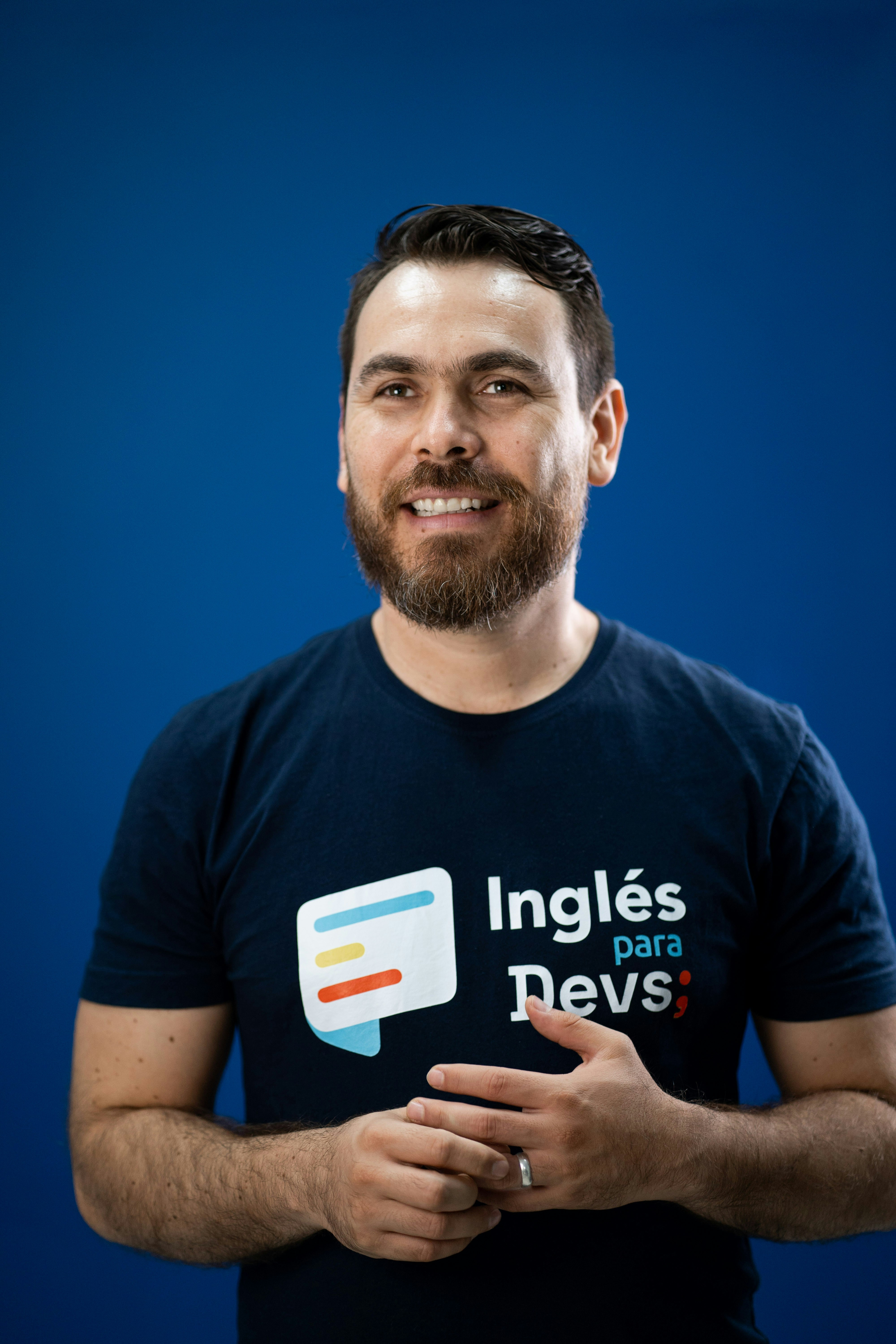 A man in a black shirt is holding his hands together