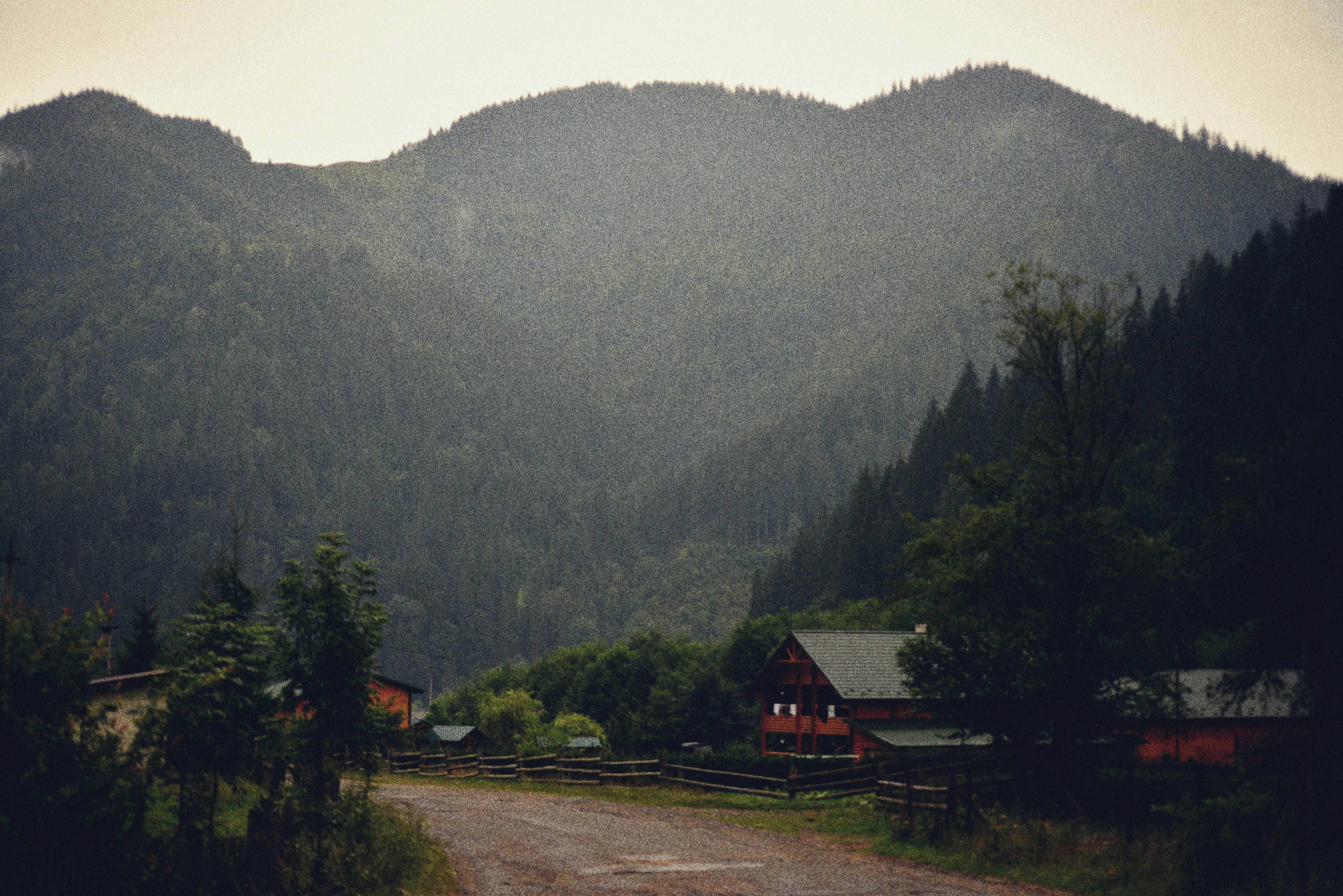 A dirt road in front of a mountain range